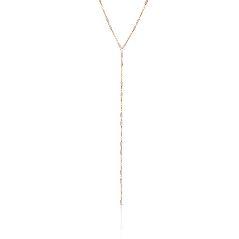 A gold lariat necklace with small metallic chain details and a silver accent, displayed against a white background.